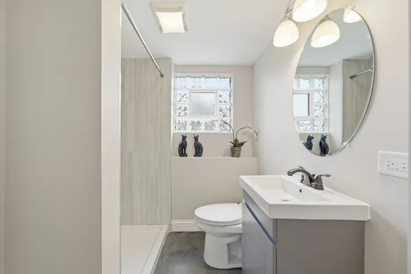 a bathroom with a sink a toilet and a mirror