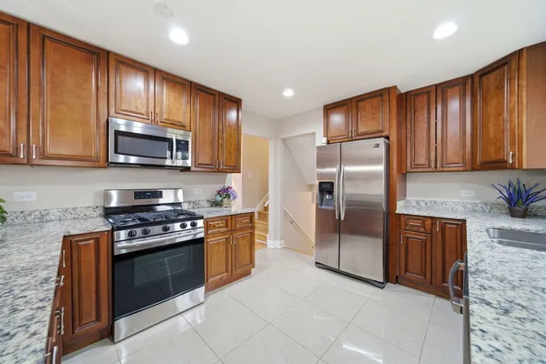 a kitchen with stainless steel appliances granite countertop a stove a refrigerator and a microwave