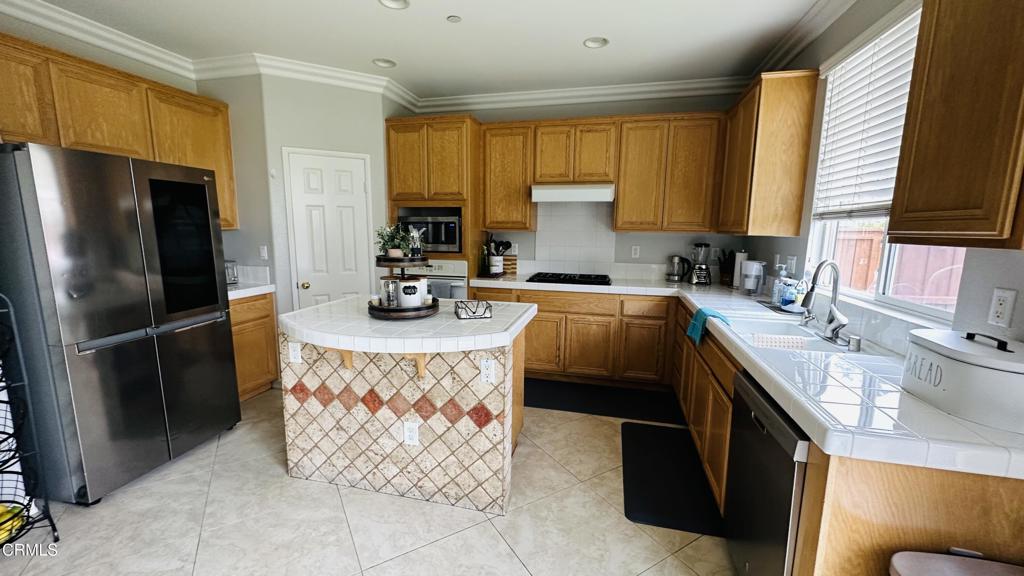 350 Huerta Street Oxnard, CA 93030 - Photo 3 of 11 a kitchen with stainless steel appliances granite countertop a sink stove refrigerator and a window