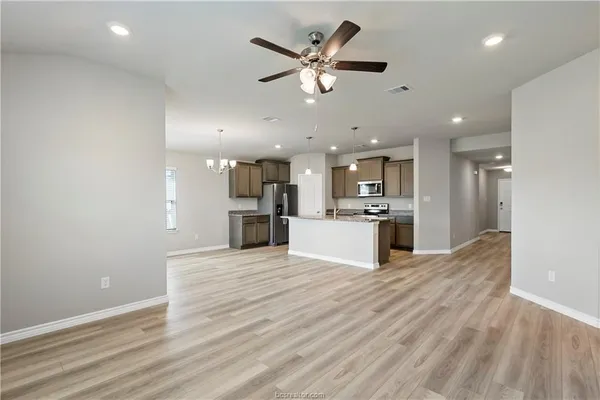 a view of kitchen with kitchen island white cabinets and refrigerator