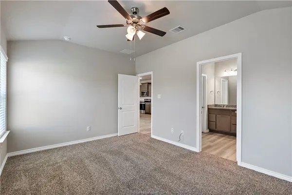 an empty room with a ceiling fan and a window