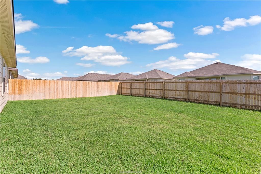 2119 Chief Street Bryan, TX 77807 - Photo 22 of 23 a view of a backyard with grass and a large tree