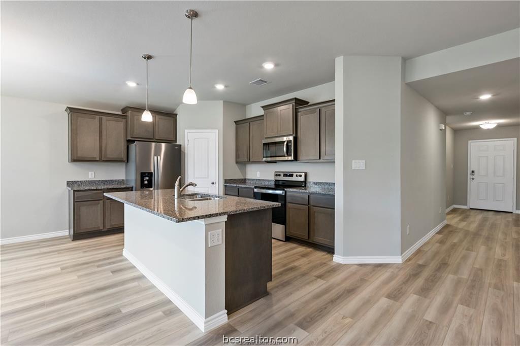 2119 Chief Street Bryan, TX 77807 - Photo 4 of 23 a kitchen with kitchen island a sink stainless steel appliances and cabinets