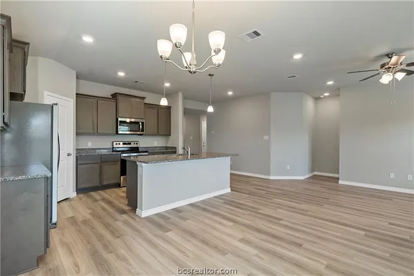 a view of kitchen with refrigerator microwave and stove