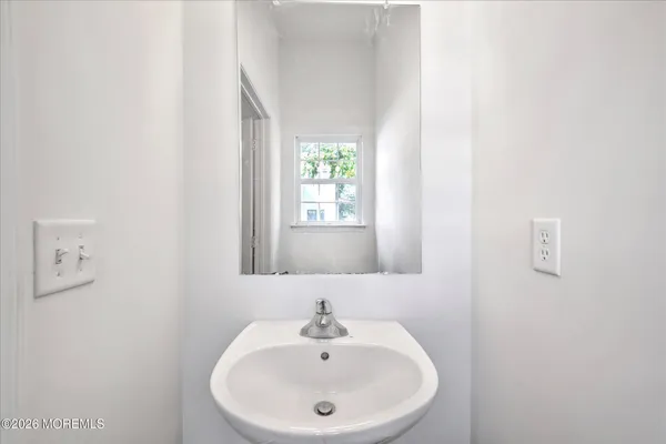 a view of a kitchen with a stove cabinets a ceiling fan and wooden floor