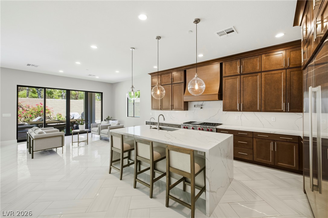 45 Garibaldi Way Henderson, NV 89011 - Photo 72 of 74 An open concept floorplan seamlessly connects the contemporary kitchen to the well-lit living area with outdoor access.
