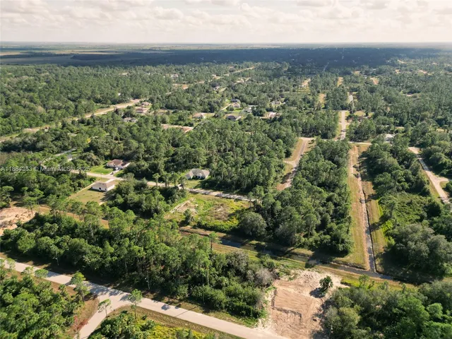 an aerial view of a residential houses with yard