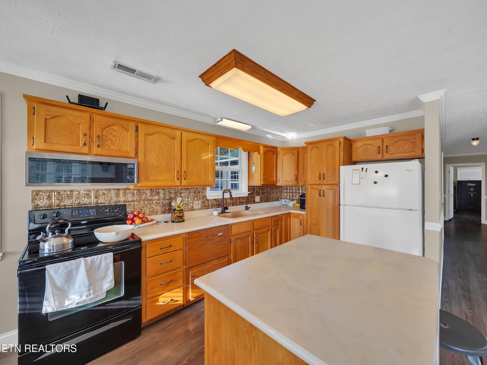 9256 Hines Valley Road Lenoir City, TN 37771 - Photo 16 of 46 a kitchen with stainless steel appliances granite countertop a refrigerator a sink dishwasher a stove with white cabinets and wooden floor