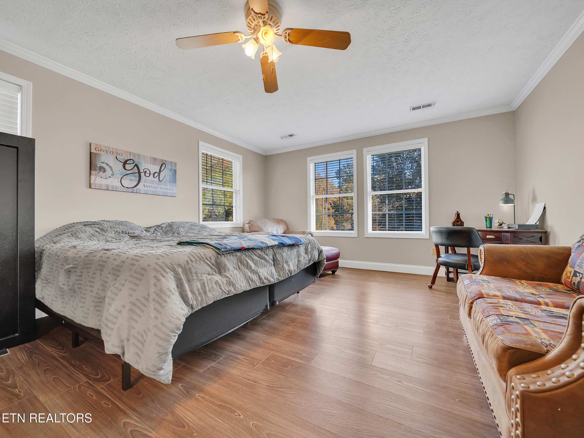 9256 Hines Valley Road Lenoir City, TN 37771 - Photo 26 of 46 a spacious bedroom with a bed a couch and a chandelier