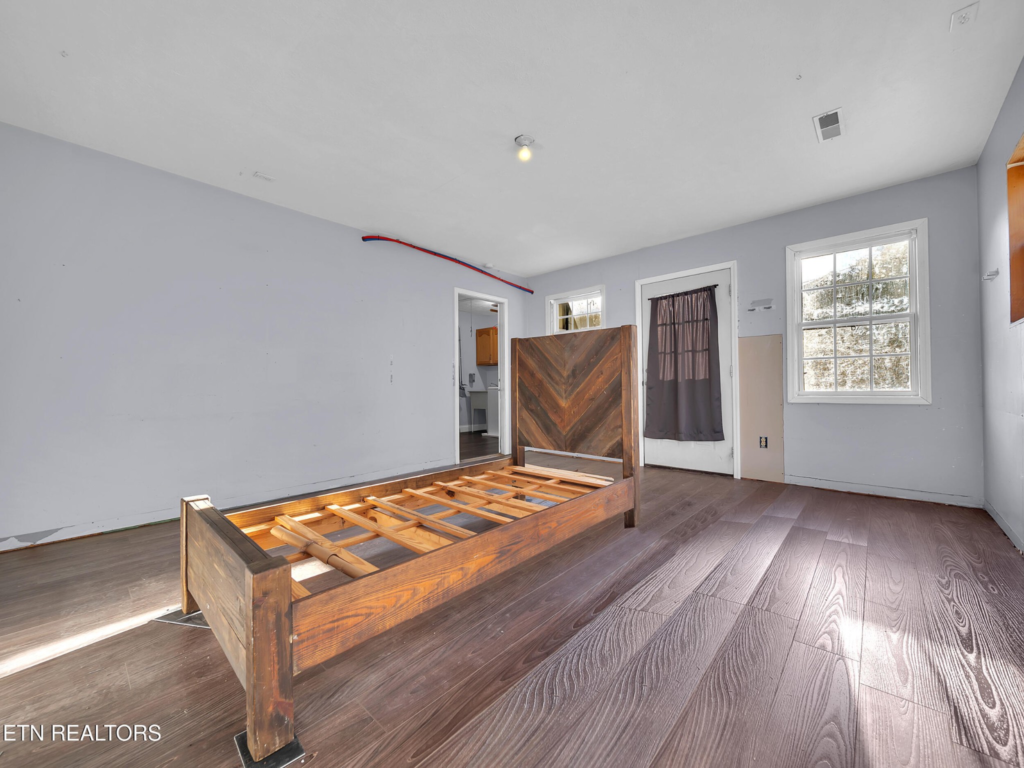 9256 Hines Valley Road Lenoir City, TN 37771 - Photo 35 of 46 a bedroom with a bed and wooden floor