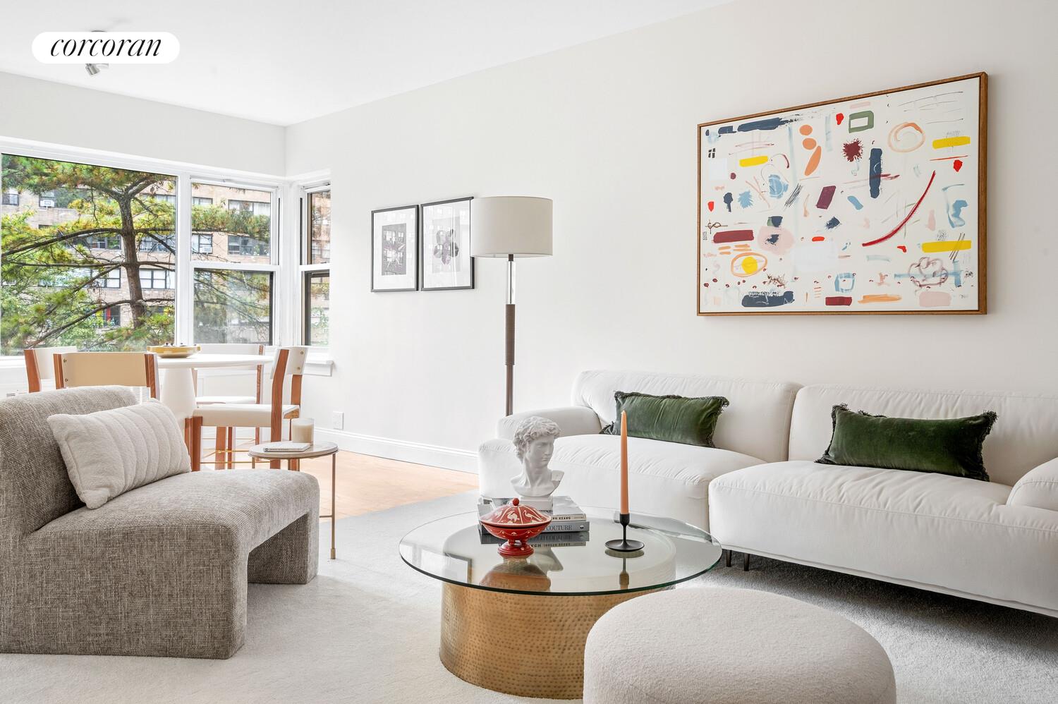 430 East 56th Street, Unit 3A Manhattan, NY 10022 - Photo 3 of 8 a living room with furniture and a large window