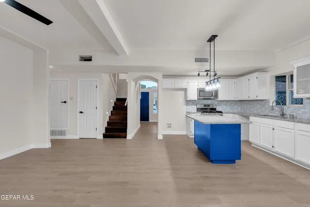 a kitchen with stainless steel appliances kitchen island granite countertop a sink and cabinets