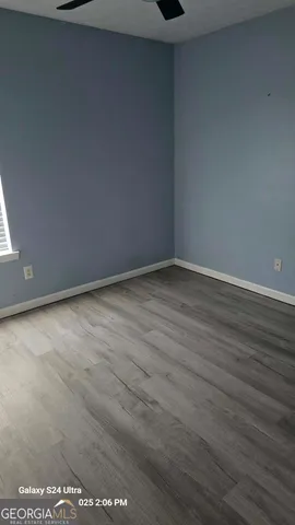 a view of an empty room with wooden floor
