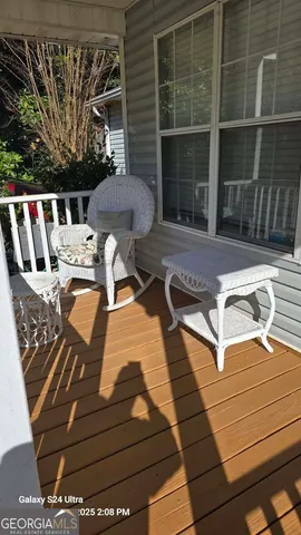 a view of a patio with table and chairs with wooden floor and fence