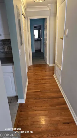 a view of a hallway with wooden floor and staircase