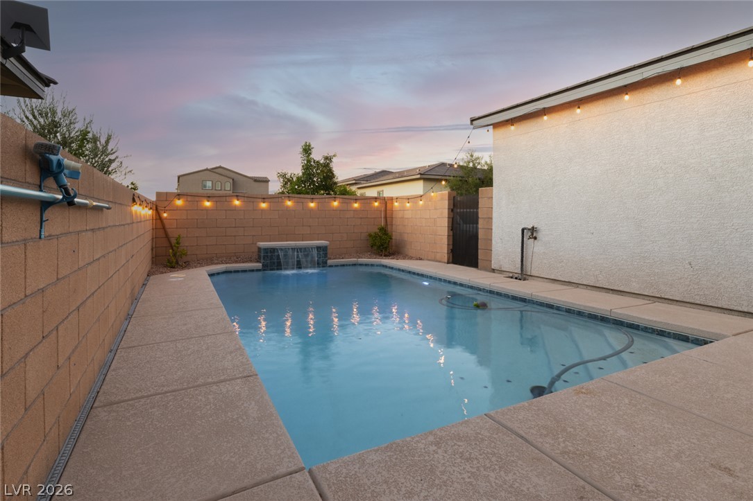 920 East Sunset Road Henderson, NV 89011 - Photo 22 of 33 An inviting private pool area with a serene waterfall feature, perfect for evening relaxation.