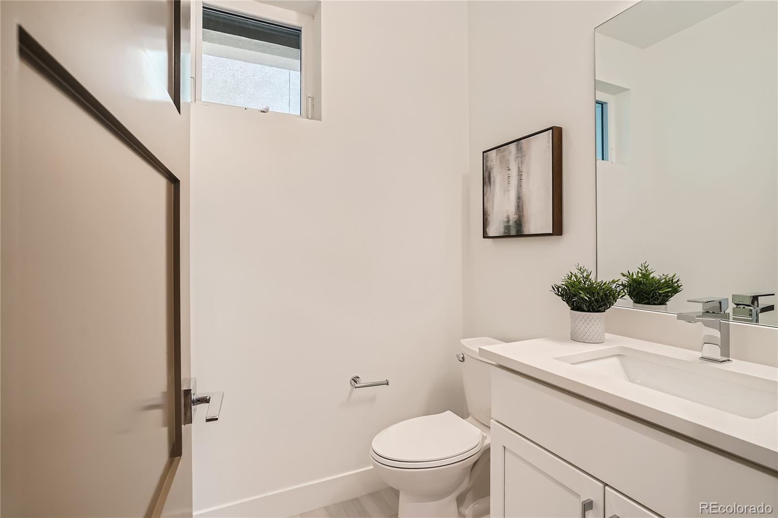 1255 Perry Street Denver, CO 80204 - Photo 15 of 28 a bathroom with a sink a toilet and mirror