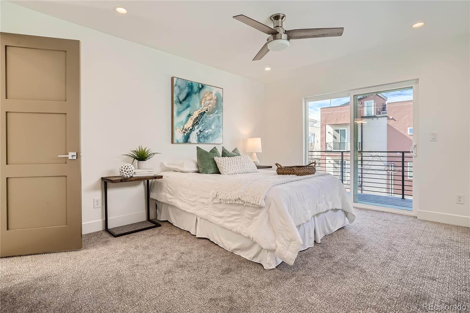 1255 Perry Street Denver, CO 80204 - Photo 16 of 28 a spacious bedroom with a bed and a cabinets