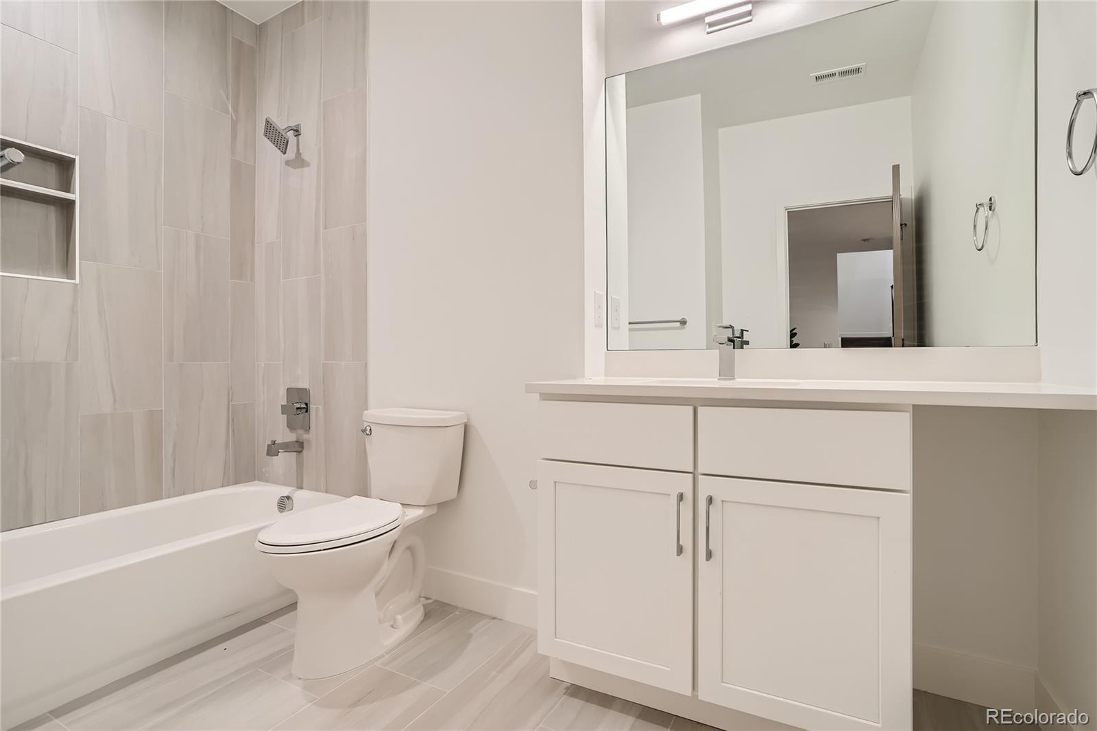 1255 Perry Street Denver, CO 80204 - Photo 9 of 28 a bathroom with a sink a toilet and shower