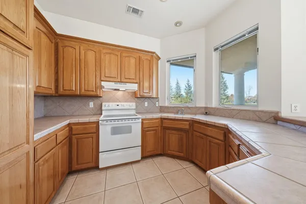 a kitchen with a stove sink and cabinets