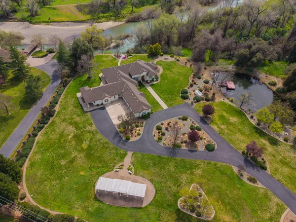 an aerial view of a swimming pool with outdoor seating and yard