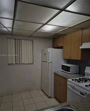 a kitchen with a stove a refrigerator and cabinets