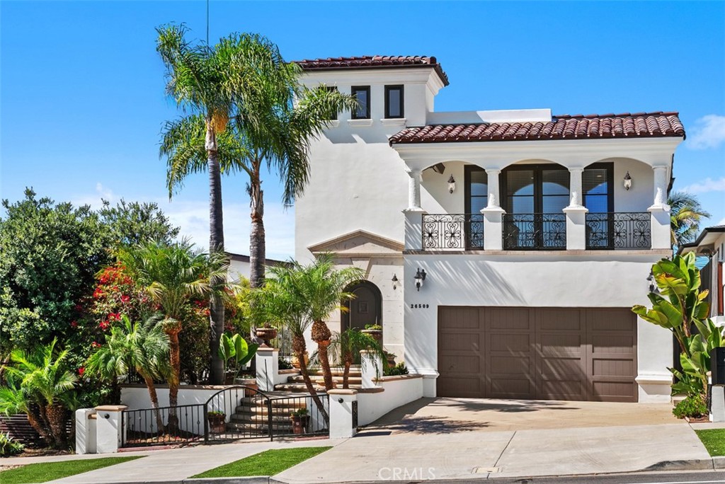 a front view of a house with garage and plants