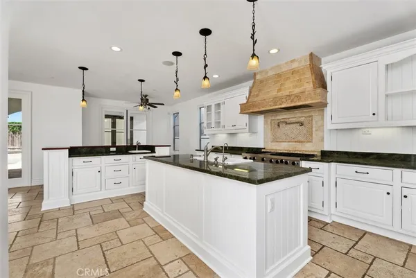 a kitchen with stainless steel appliances granite countertop a stove a sink and a refrigerator