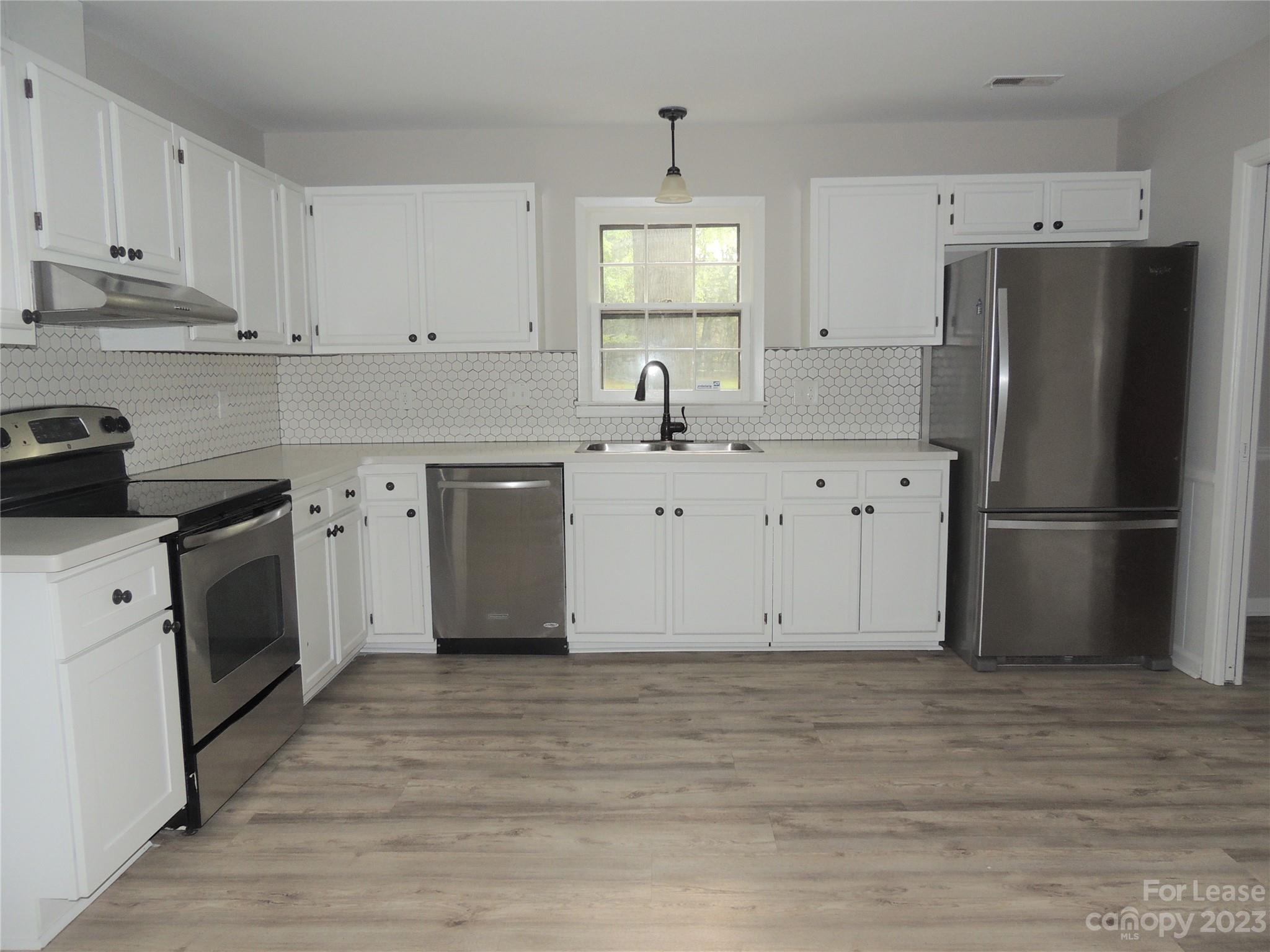 8700 Houston Ridge Road Charlotte, NC 28277 - Photo 6 of 29 a kitchen with cabinets stainless steel appliances a sink and wooden floor