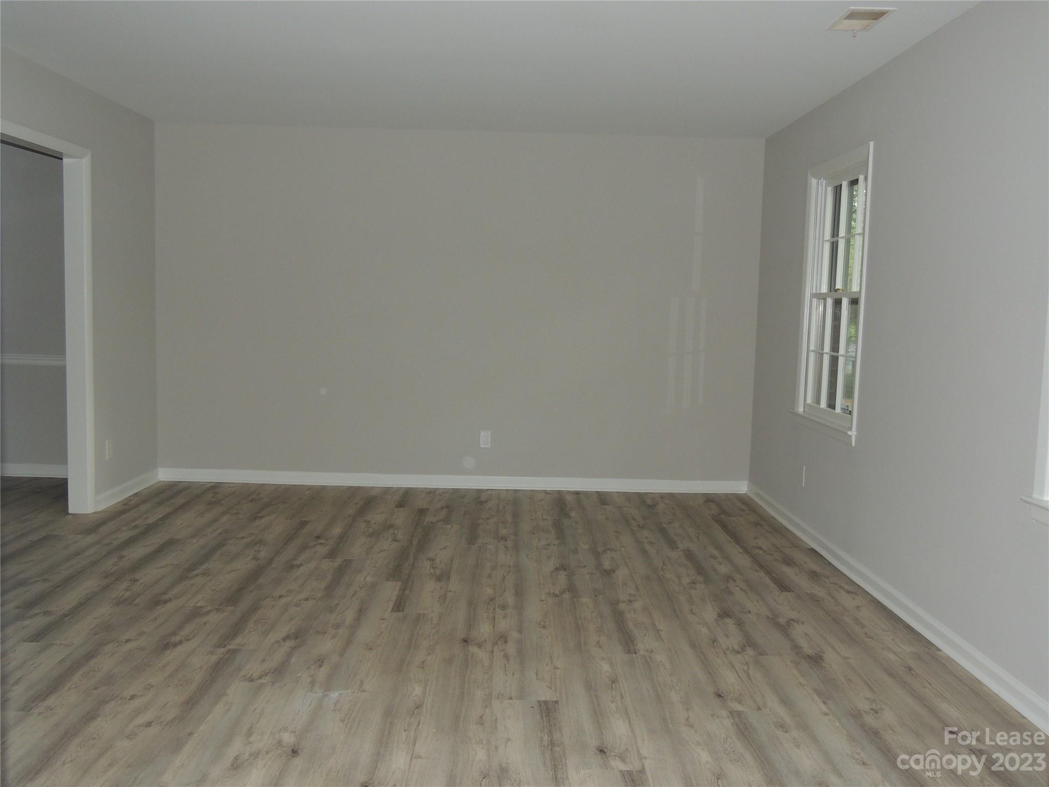 8700 Houston Ridge Road Charlotte, NC 28277 - Photo 10 of 29 an empty room with wooden floor and windows