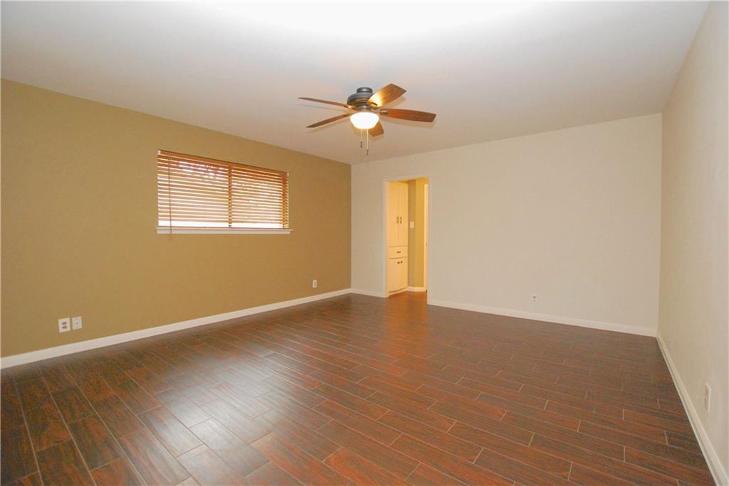 11724 Running Fox Trail Austin, TX 78759 - Photo 12 of 18 a view of an empty room with wooden floor and a window