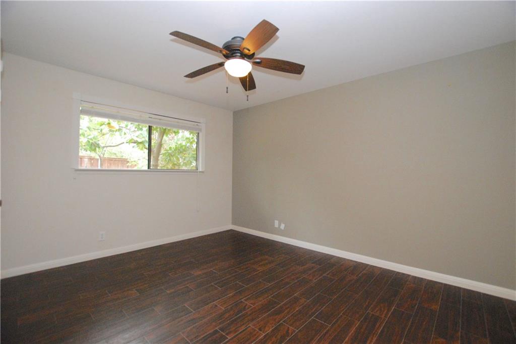 11724 Running Fox Trail Austin, TX 78759 - Photo 16 of 18 an empty room with wooden floor and windows