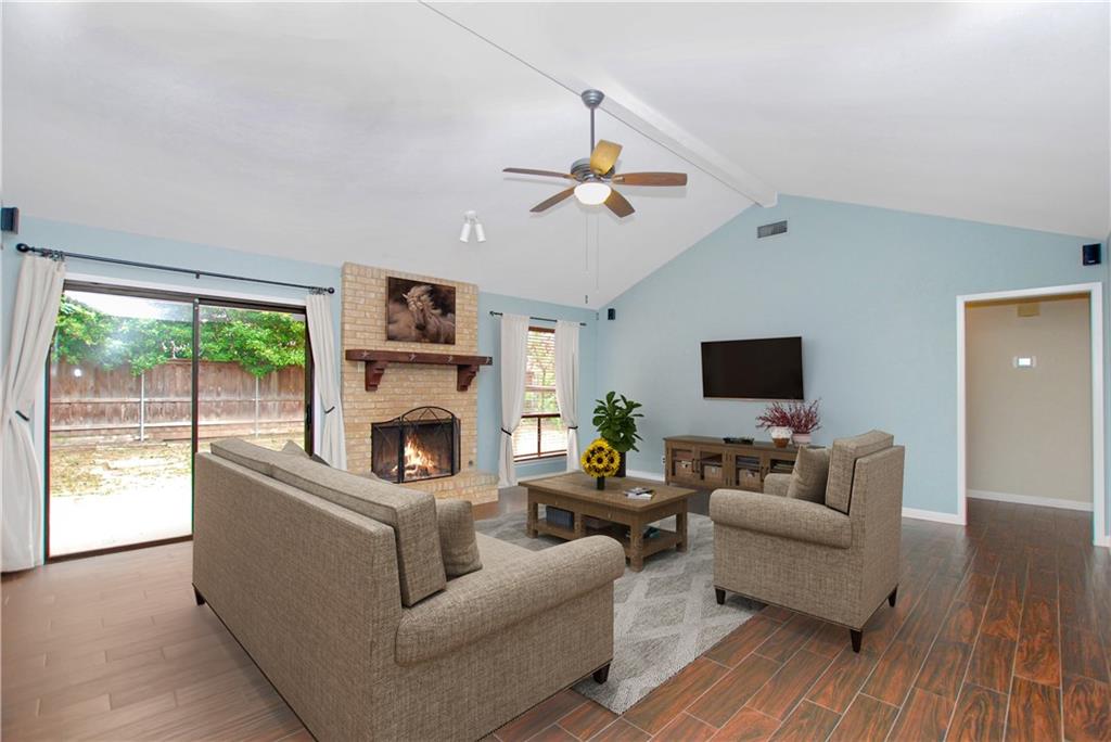 11724 Running Fox Trail Austin, TX 78759 - Photo 3 of 18 a living room with furniture a fireplace and a flat screen tv