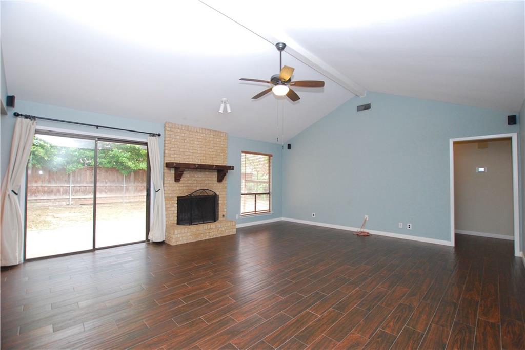 11724 Running Fox Trail Austin, TX 78759 - Photo 4 of 18 a view of empty room with wooden floor and fireplace