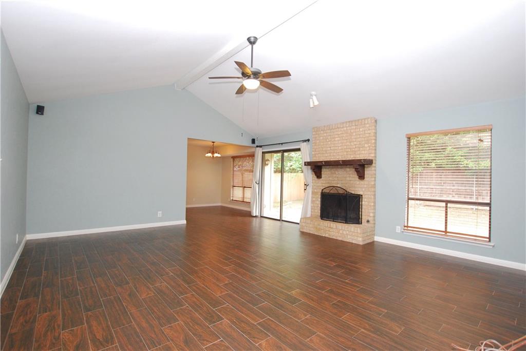 11724 Running Fox Trail Austin, TX 78759 - Photo 5 of 18 an empty room with windows fireplace and wooden floor