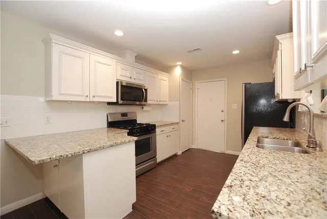 a kitchen with granite countertop stainless steel appliances and wooden cabinets