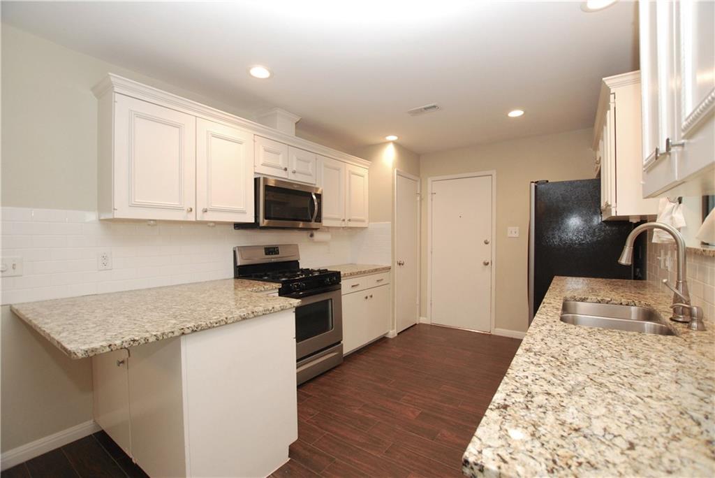 11724 Running Fox Trail Austin, TX 78759 - Photo 7 of 18 a kitchen with granite countertop stainless steel appliances and wooden cabinets