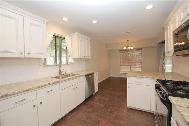 a kitchen with a sink stove and cabinets