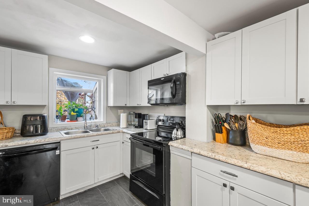 7002 Killarney Street Clinton, MD 20735 - Photo 11 of 26 a kitchen with stainless steel appliances granite countertop a sink a stove a microwave a sink and cabinets