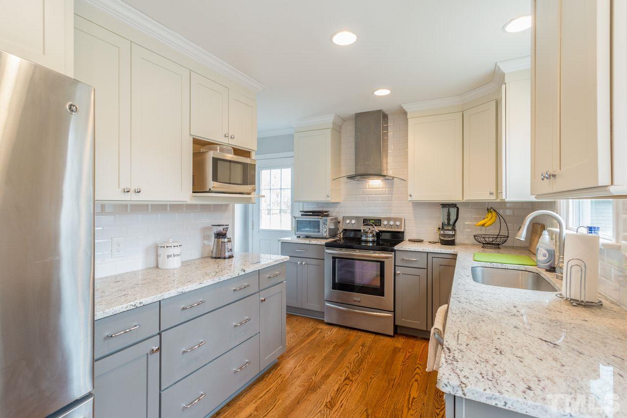 6108 Ivy Ridge Road Raleigh, NC 27612 - Photo 11 of 23 a kitchen with granite countertop cabinets stainless steel appliances and a sink
