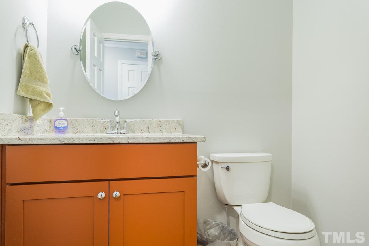 6108 Ivy Ridge Road Raleigh, NC 27612 - Photo 14 of 23 a bathroom with a granite countertop toilet sink mirror and vanity