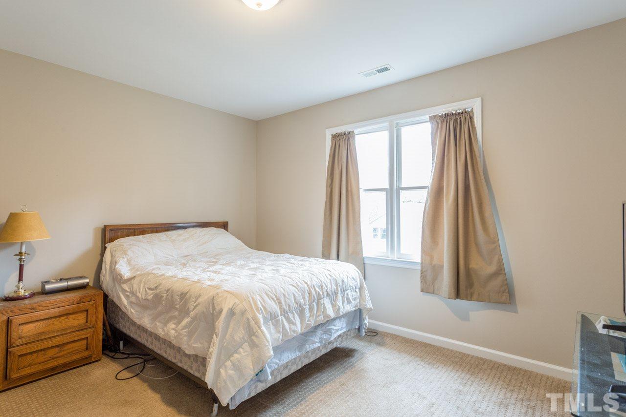 6108 Ivy Ridge Road Raleigh, NC 27612 - Photo 16 of 23 a bed sitting in a bedroom next to a window