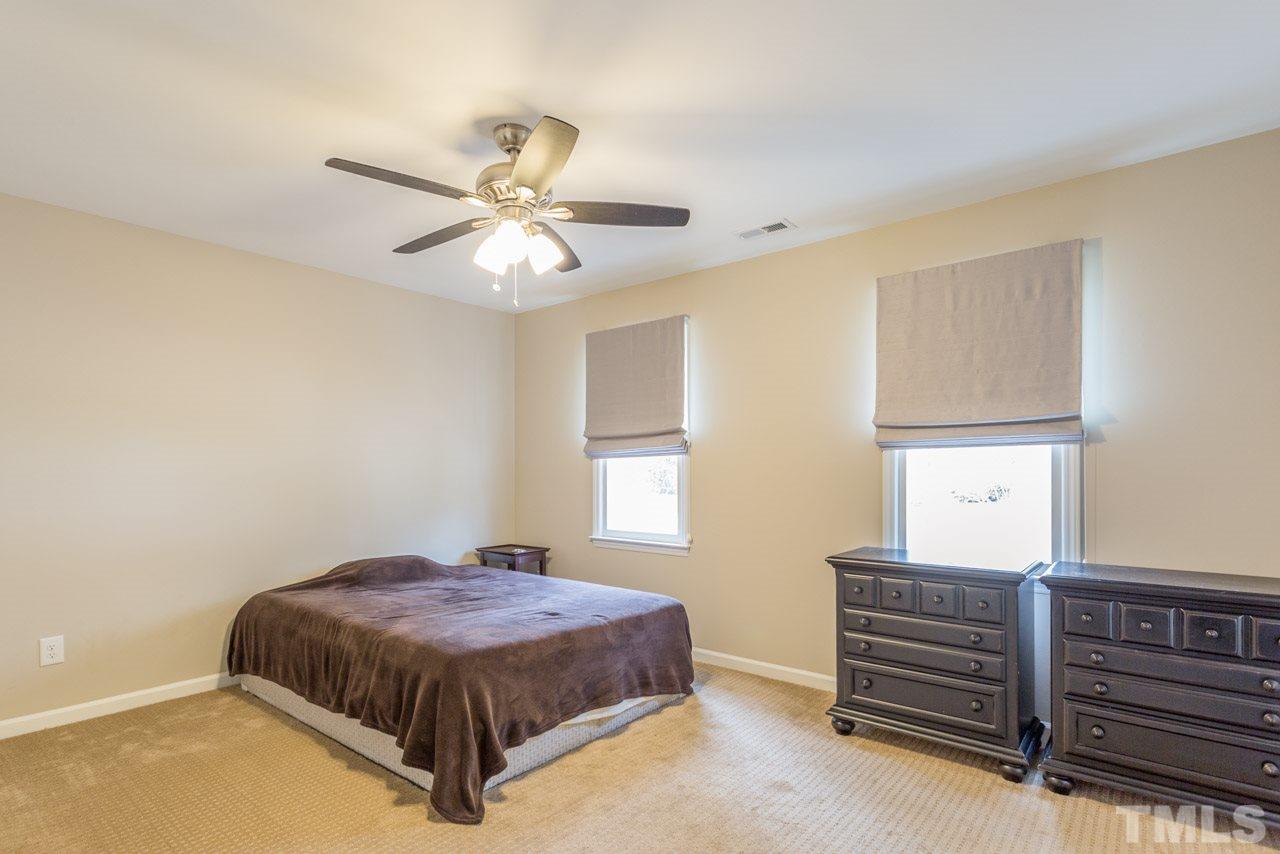6108 Ivy Ridge Road Raleigh, NC 27612 - Photo 21 of 23 a bedroom with a bed and a chandelier