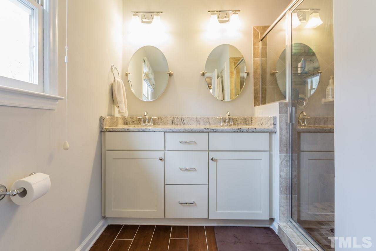 6108 Ivy Ridge Road Raleigh, NC 27612 - Photo 23 of 23 a bathroom with a double vanity sink and a mirror
