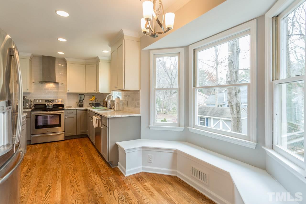 6108 Ivy Ridge Road Raleigh, NC 27612 - Photo 9 of 23 a kitchen with a sink a counter top space stainless steel appliances and a large window