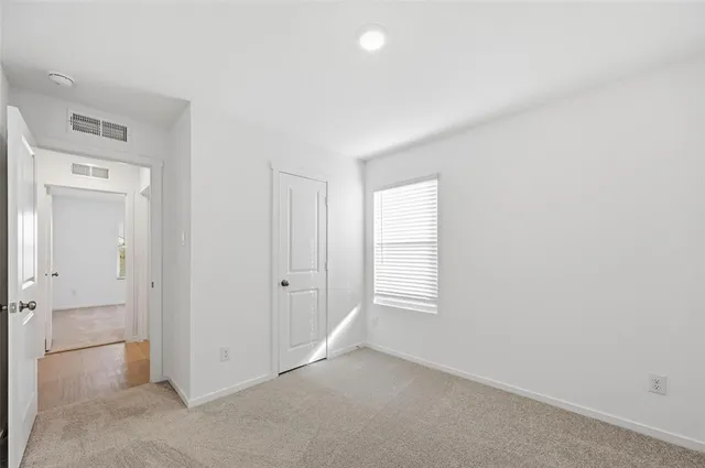 an empty room with windows and closet