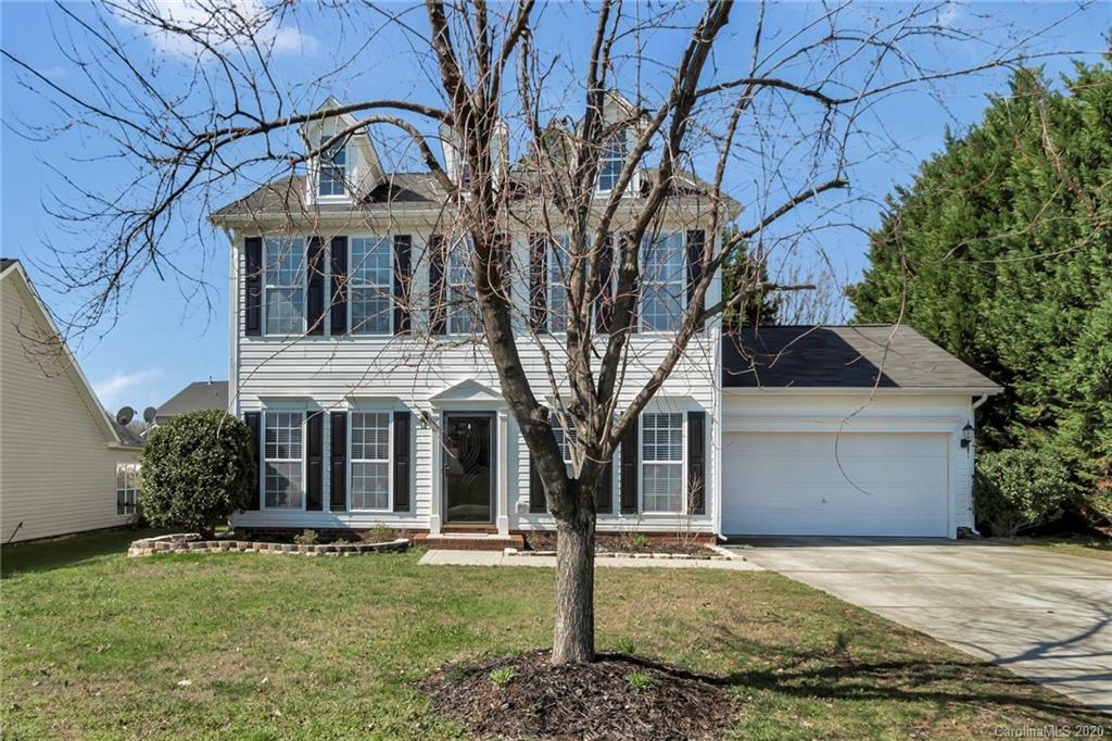 5548 Alexandrite Way, Unit 422 Fort Mill, SC 29708 - Photo 2 of 35 a front view of a house with a garden and trees