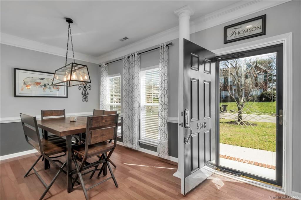 5548 Alexandrite Way, Unit 422 Fort Mill, SC 29708 - Photo 16 of 35 a view of a dining room with furniture a chandelier and wooden floor