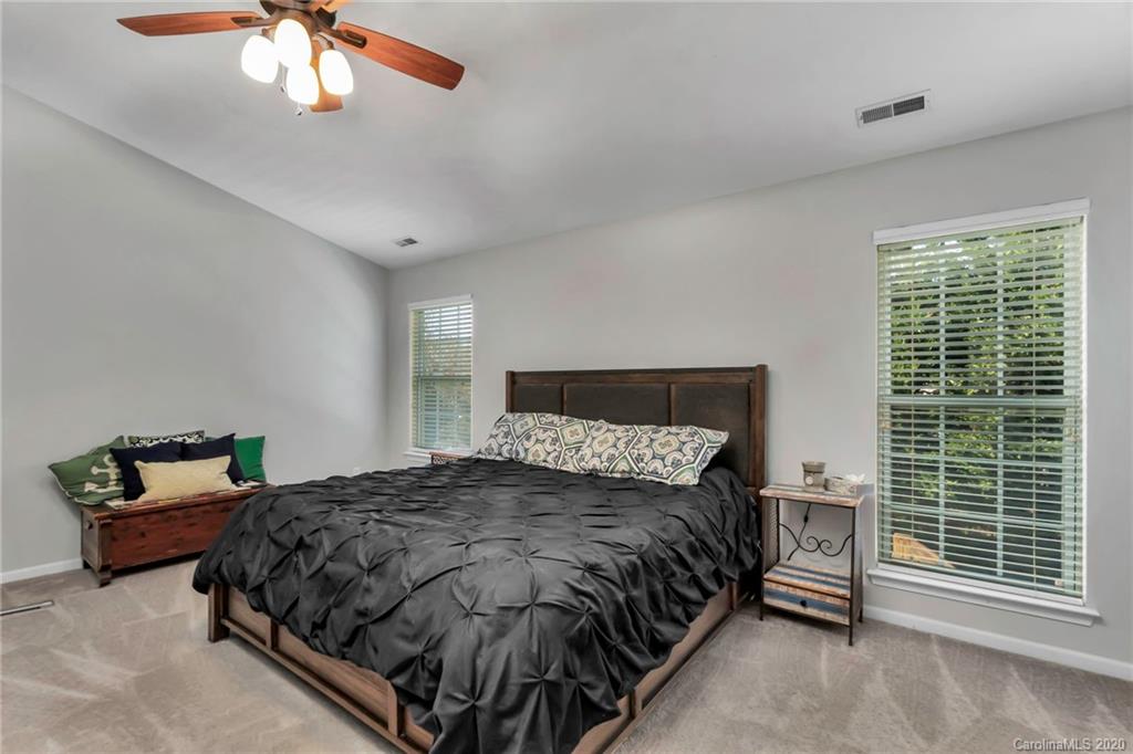 5548 Alexandrite Way, Unit 422 Fort Mill, SC 29708 - Photo 18 of 35 a bedroom with a bed and a chandelier