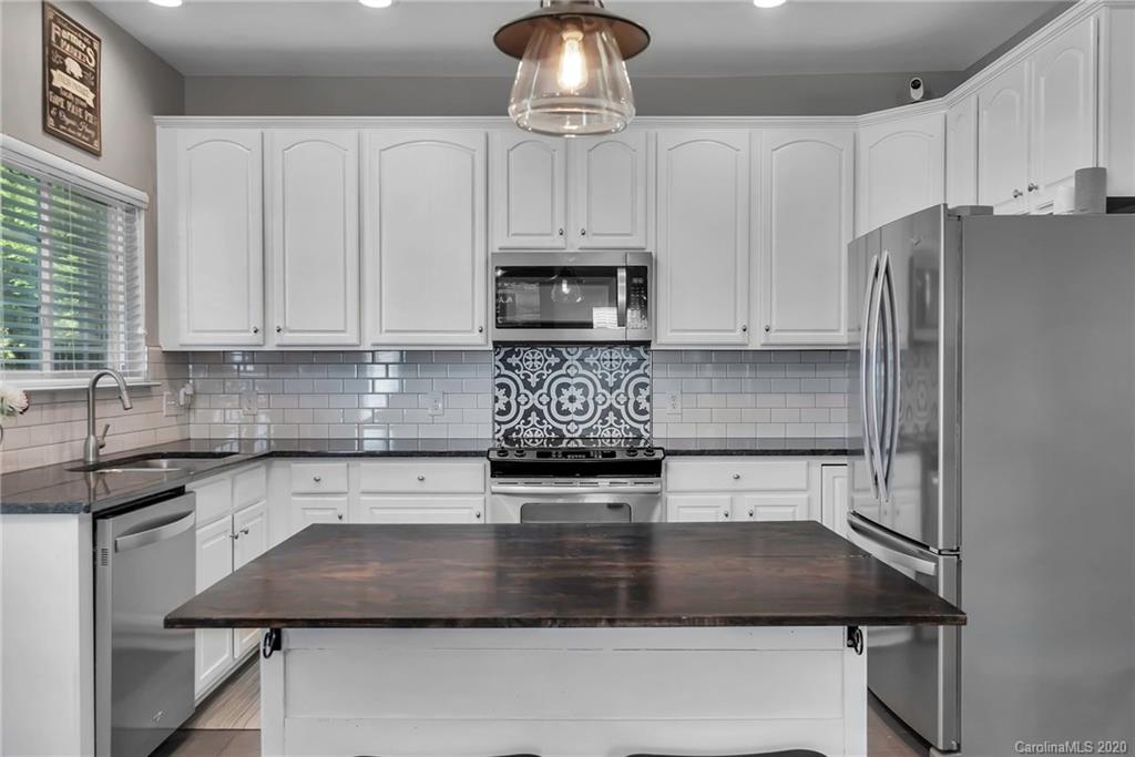 5548 Alexandrite Way, Unit 422 Fort Mill, SC 29708 - Photo 5 of 35 a kitchen with stainless steel appliances granite countertop a sink a stove a refrigerator a microwave and cabinets